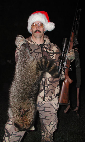 pete hauer in a santa claus hat posing with a racoon